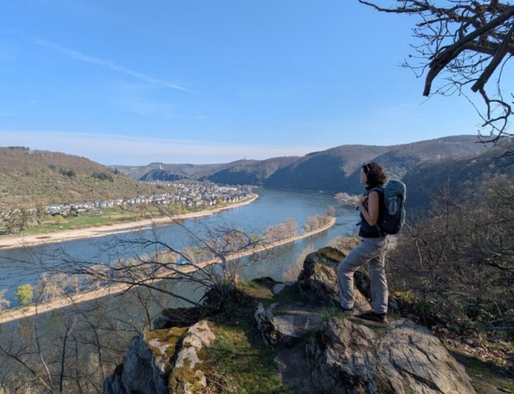 Wanderguide Linda Bluemel steht auf einem Felsen mit Blick auf den Rhein.